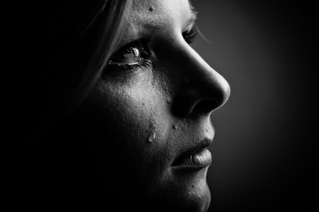 Tears flow as a woman grieves a loss. Learn how to cope