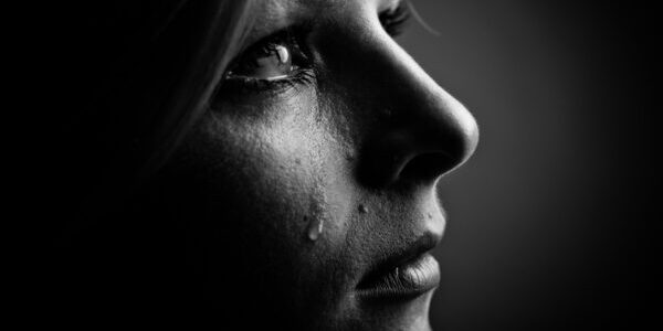 Tears flow as a woman grieves a loss. Learn how to cope